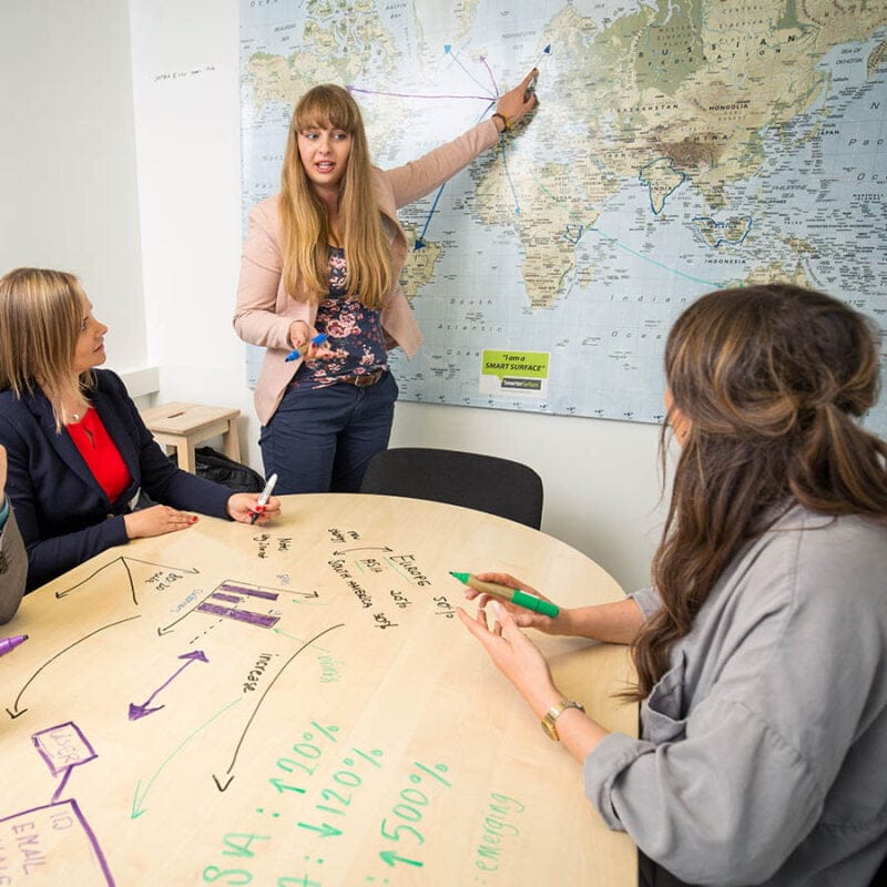 Pintura pizarra transparente sobre el mapa mundial y de una mesa en una sala de reuniones