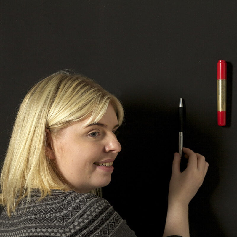 Mujer pegando objetos sobre pintura súper magnética para paredes
