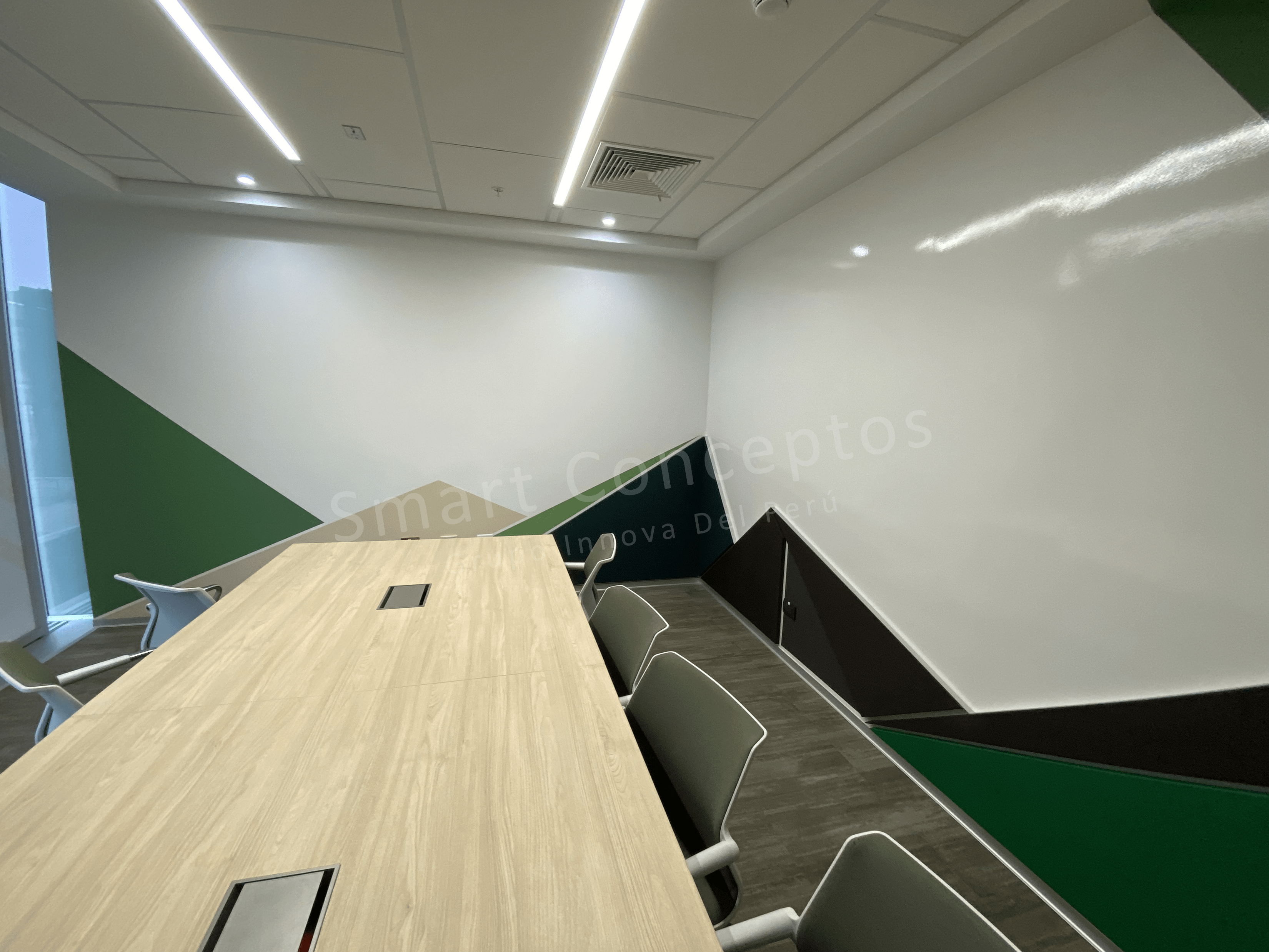 Arquitectos/Diseñadores_Una sala de reuniones con paredes con diseños verdes con con pintura pizarra